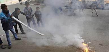 Children play with a flaming lump, allegedly containing white phosphorus, in the northern Gaza Strip on Monday